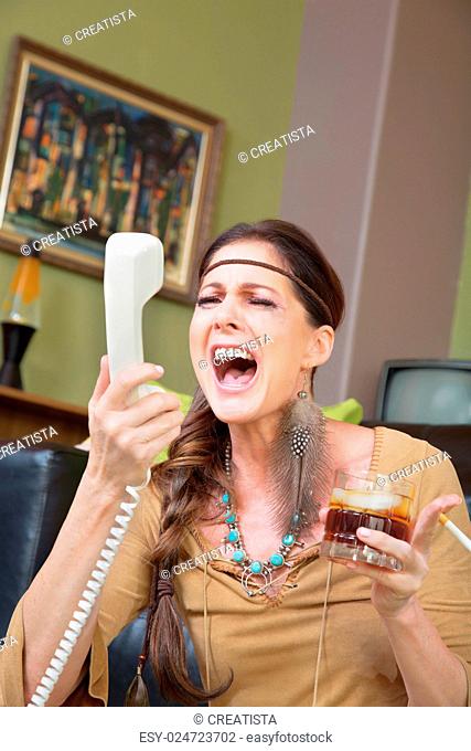 Single woman with drink singing into telephone