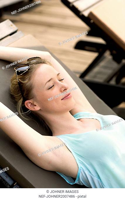 Young woman relaxing on lounge chair