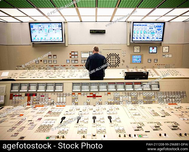 02 December 2021, Schleswig-Holstein, Brokdorf: An employee stands at a control panel in the control room of the Brokdorf nuclear power plant