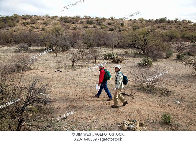 Arivaca Junction, Arizona - Jim Marx red jacket and Charlie Rooney, volunteers with No More Deaths, carry food and water as they patrol desert trails  The...