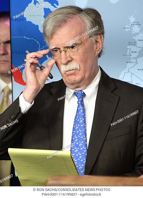 National Security Advisor John R. Bolton adjusts his glasses as he conducts a briefing with United States Secretary of the Treasury Steven T