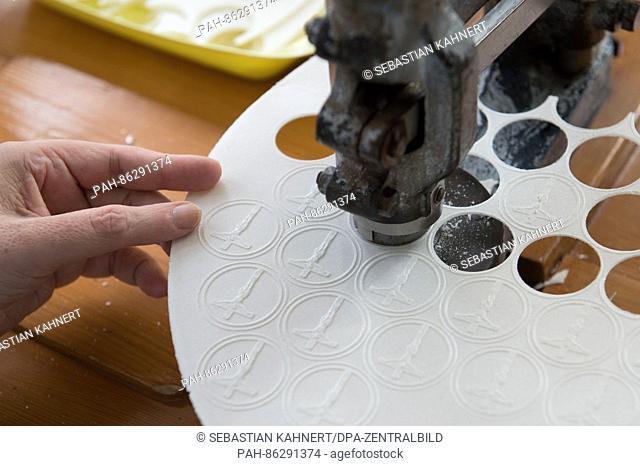 A worker presses out communion wafers in a bakery specialised in their production based in a Christian social services institute in Dresden, Germany