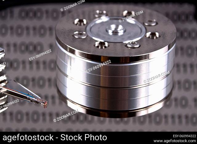 open spinig hard drive closeup on reading head with binary reflected data