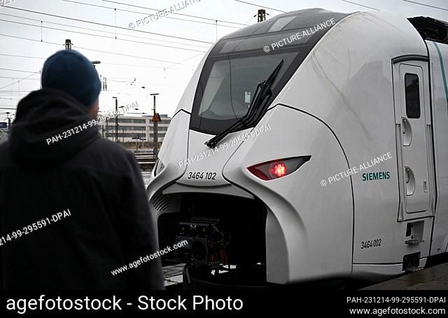 14 December 2023, Saxony, Leipzig: A man looks at a model of a new S-Bahn train at Leipzig Central Station. The new trains are due to run on the Central German...