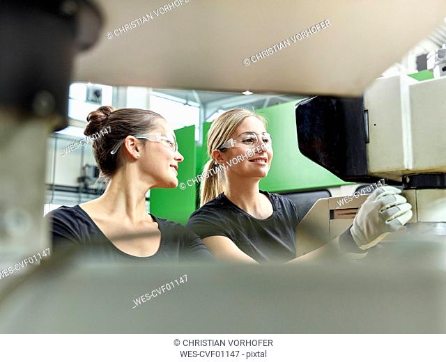 Two women working on a machine
