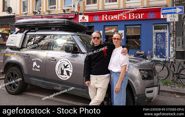 28 September 2023, Hamburg: Hamburg neighborhood celebrity Michel Ruge (l) and his wife Annika Ruge stand in front of their car in front of the cult pub...