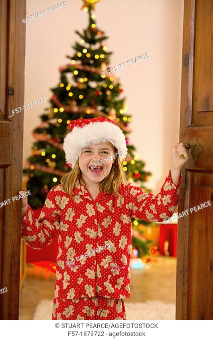 Young girl opening the living room doors at Christmas time