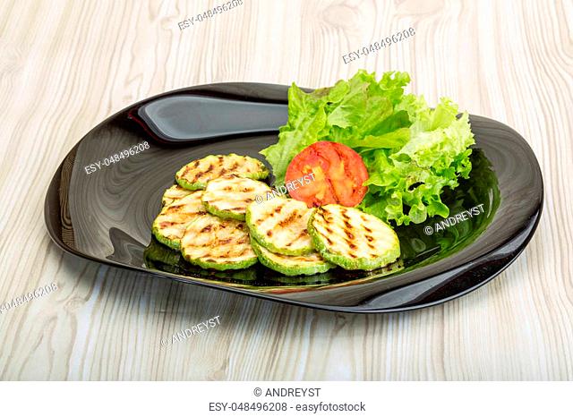 Grilled zucchini in the bowl with salad leaves