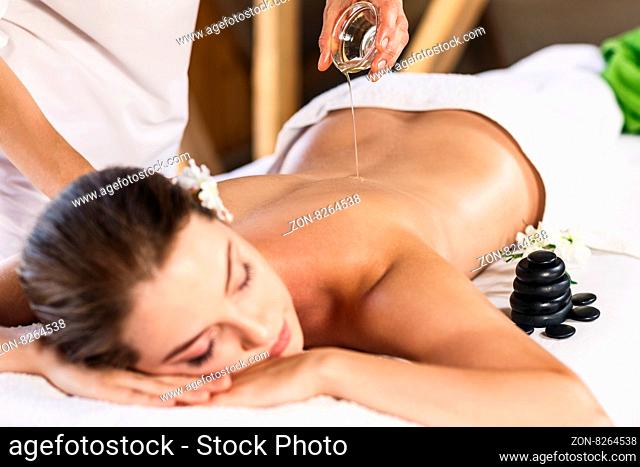 Young beautiful woman lying on massage table and enjoying massage