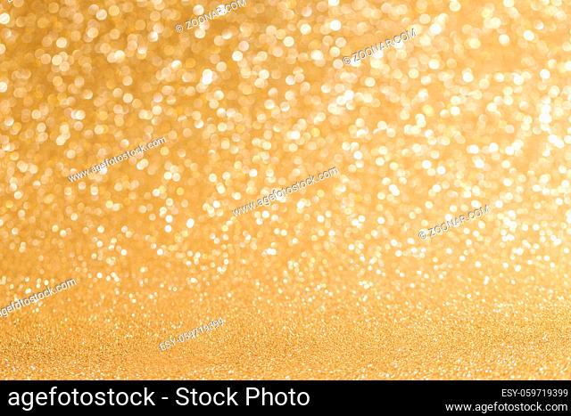 Golden festive glitter background with defocused lights