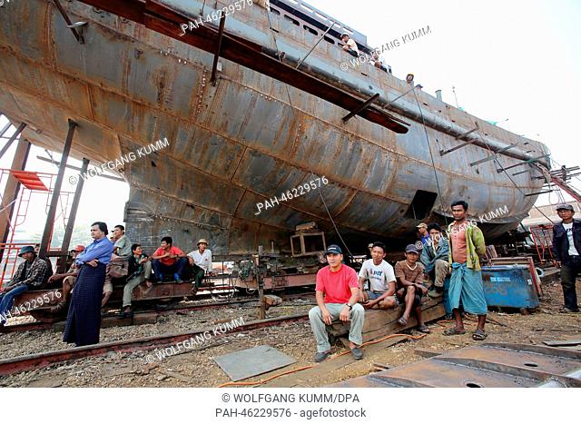 Dock workers sit in front of a vessel under construction during a baptism ceremony of a converted passanger boat, called the 'Swimming Doctors 2' (not in...