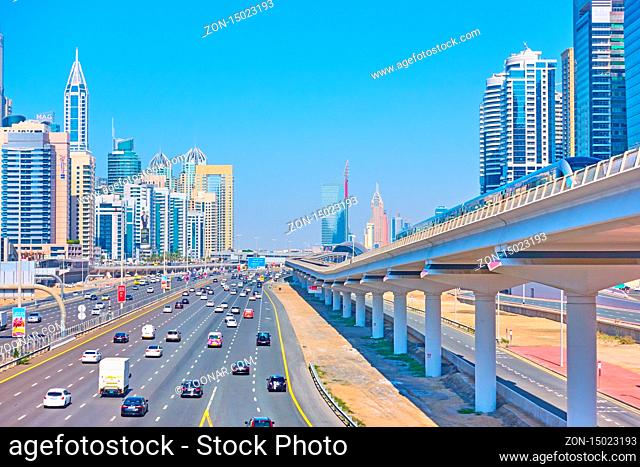 Dubai, OAE - January 30, 2020: Perspective of Sheikh Zayed Road with modern skyscrapers and metro line in Dubai