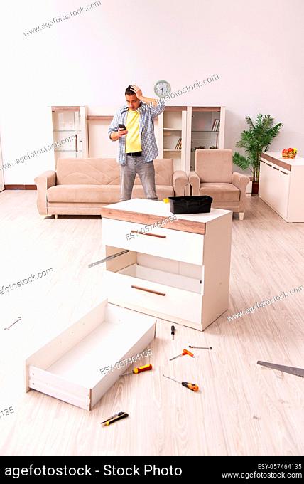 Young carpenter repairing furniture at home