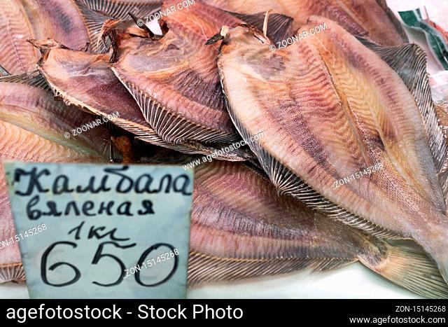 PETROPAVLOVSK CITY, KAMCHATKA PENINSULA, RUSSIAN FAR EAST - 20 MAY, 2018: Close-up view of dried salted flatfish with price on counter at fish market