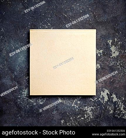 Photo of closed blank kraft brochure on concrete background. Template for placing your design. Top view with copy space. Flat lay