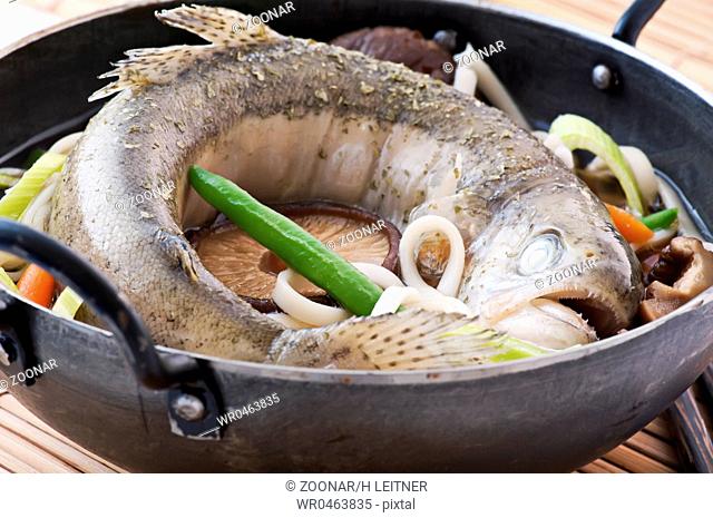 Fish soup with trout and vegetable as closeup in a pan