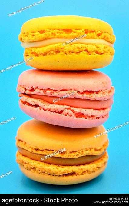 Stack of sweet french macaroons with vintage pastel colored tone on blue background