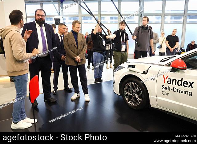RUSSIA, MOSCOW - DECEMBER 20, 2023: Russia's Digital Development, Communications and Mass Media Minister Maksut Shadayev (2nd L) looks at a Yandex self-driving...