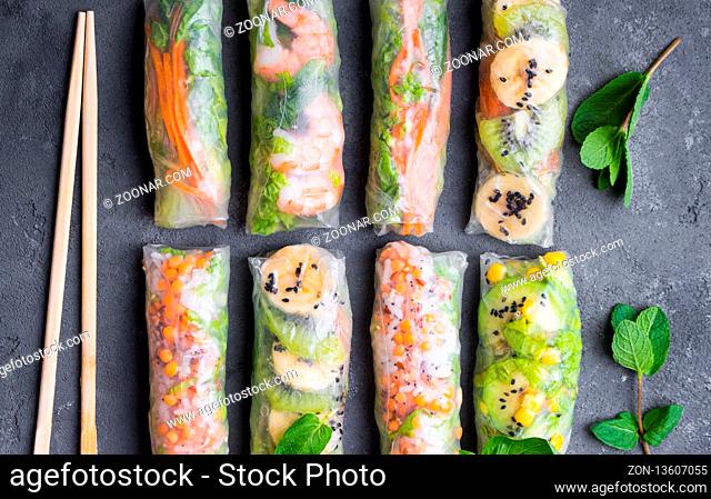 Fresh assorted spring rolls set. Handmade asian/Chinese spring rolls. Rustic concrete background. Spring rolls with shrimps, vegetables, fruits