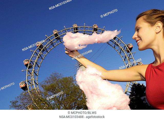 amusement park Prater Vienna, young woman with candy floss, Giant Ferry Wheel