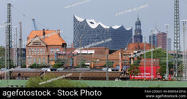 10 May 2023, Hamburg: View through the harbor with cranes and ship masts to the Elbphilharmonie and the city landmark, the main church of St
