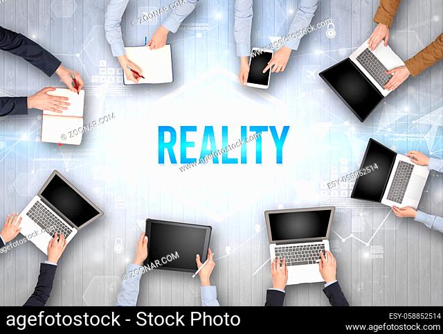 Group of Busy People Working in an Office with REALITY inscription, modern technology concept