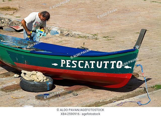 Fisherman painting the boat, Bosa, Sardinia, Italy
