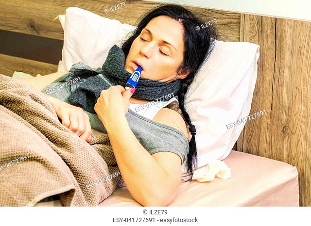 Sick woman keeping thermometer in mouth