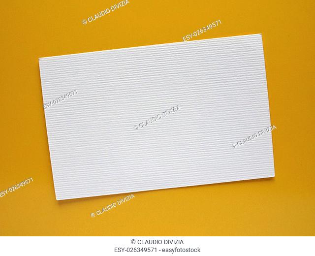 Blank paper tag label or sticker with copy space - flat lay on yellow desktop background