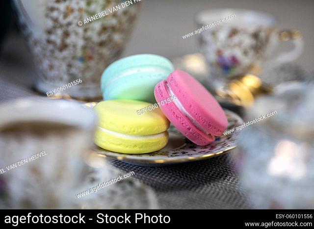 Traditional table with cup of tea and tea pot and colorful macaron lovely cozy table at home, Mother's Day tea setting with teapot, close up