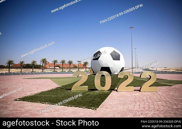 PRODUCTION - 02 April 2022, Qatar, Al Ruwais: A large ball with the year 2022 stands on a traffic island with a traffic circle in front of the Al-Shamal sports...