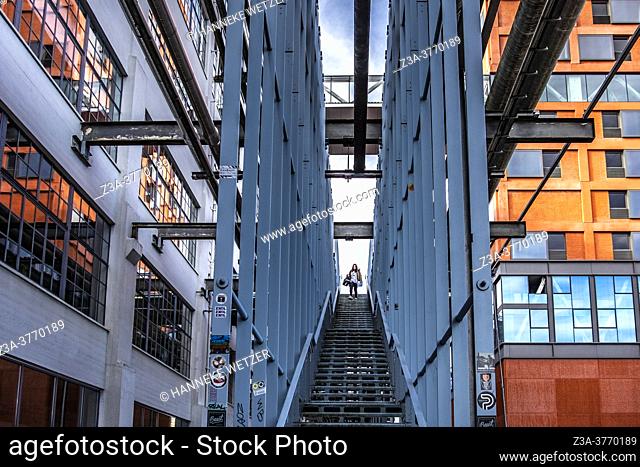 Woman walking down the stairs at Strijp-S, Eindhoven, The Netherlands, Europe