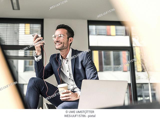 Businessman talking on the phone, using earphones