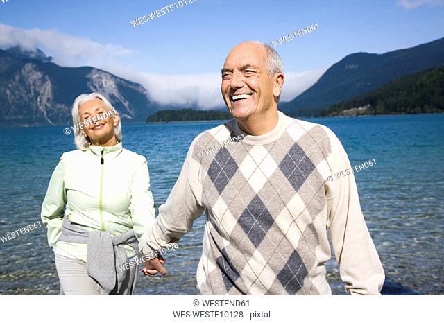 Germany, Bavaria, Walchensee, Senior couple walking hand in hand