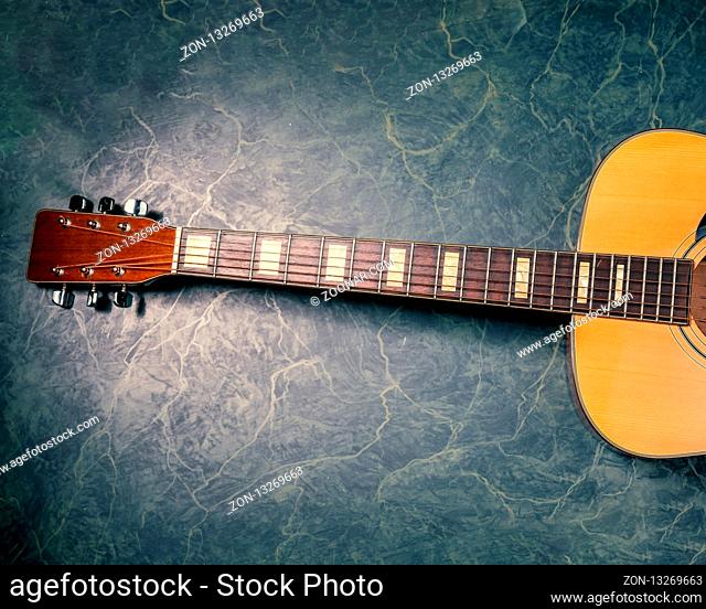 acoustic guitar on green, blue marble background, music concept