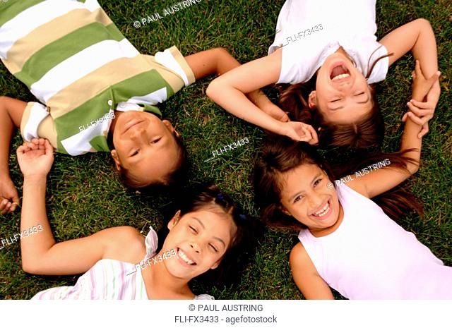 Children Lying in Circle on Grass