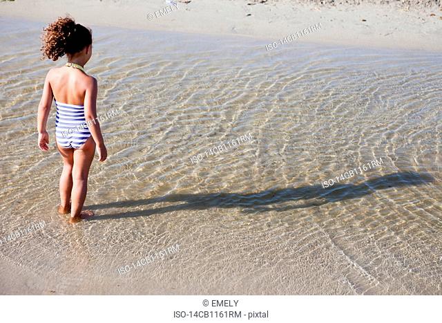 young girl playing in water at beach