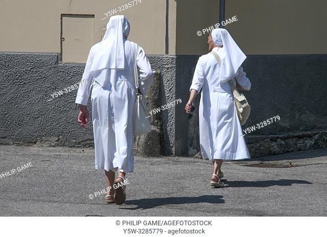 Two Christian nuns walking together in Domodossola, Piedmont, Italy