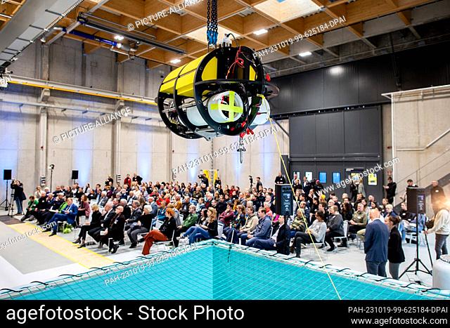 19 October 2023, Bremen, Bremerhaven: An underwater winch hangs over a plunge pool during the opening ceremony, while numerous employees of the Alfred Wegener...