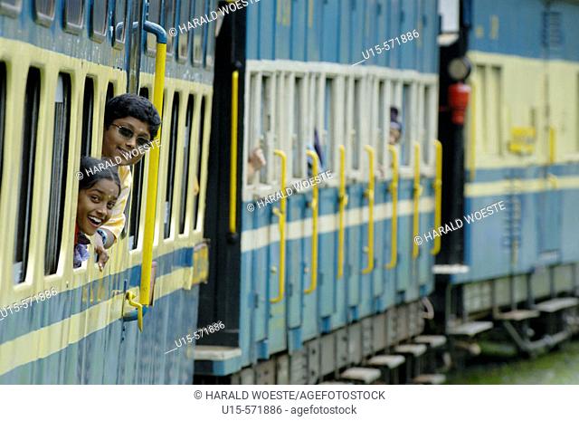 Loughing girls looking out of the train windows of the Nilgiri Mountain Railway driving from Coonoor to Ooty. Tamil Nadu, India 2005