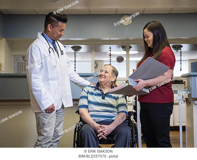 Doctor reconfortante paciente en silla de ruedas