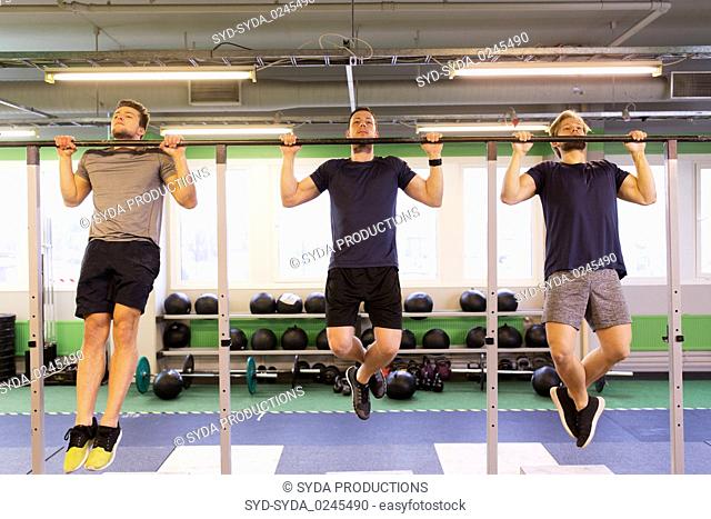 group of young men doing pull-ups in gym