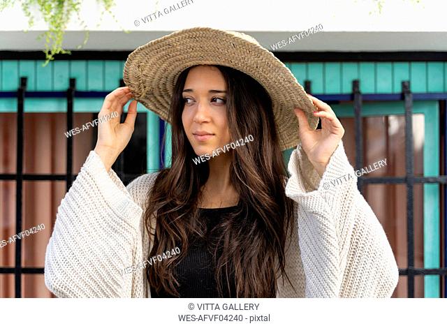 Young woman wearing sun hat and looking sideways
