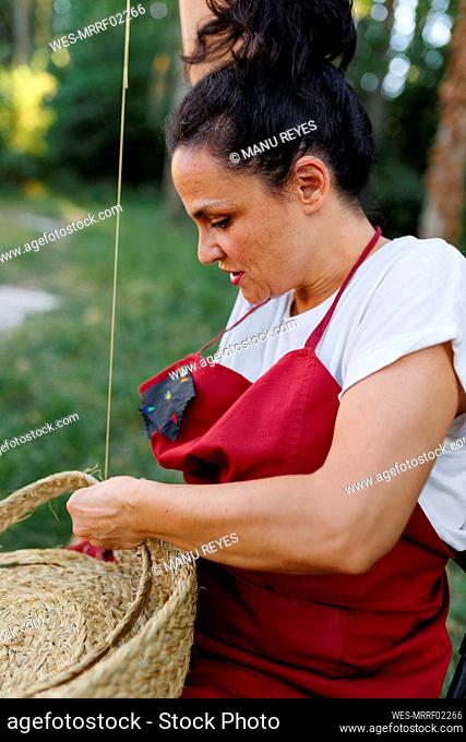 Mature artisan weaving with esparto grass