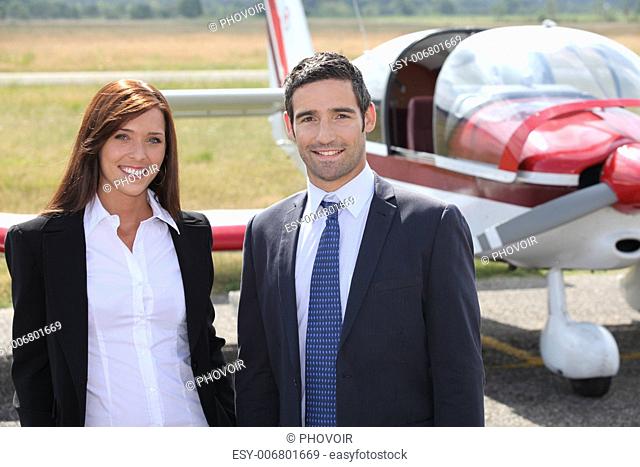 Man and woman in front of airplane