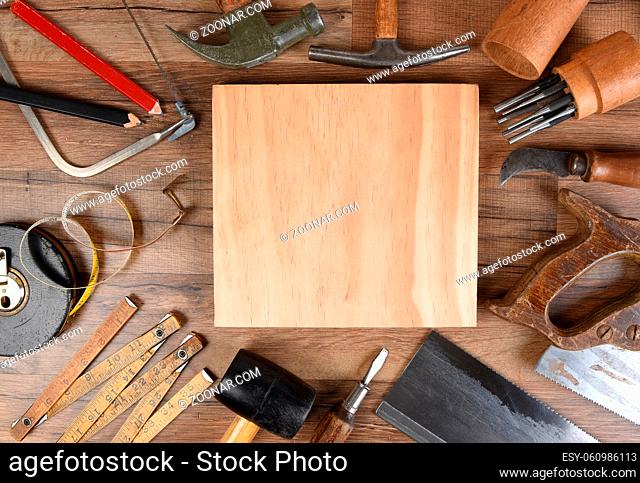 High angle closeup of a large group of tools arranged around an piece of wood, an ideal space for your copy