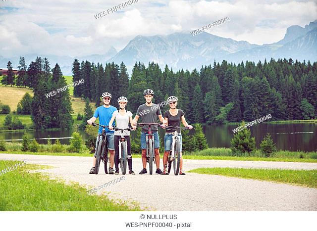 Germany, Bavaria, Pfronten, portrait of happy family with mountain bikes at ladeside