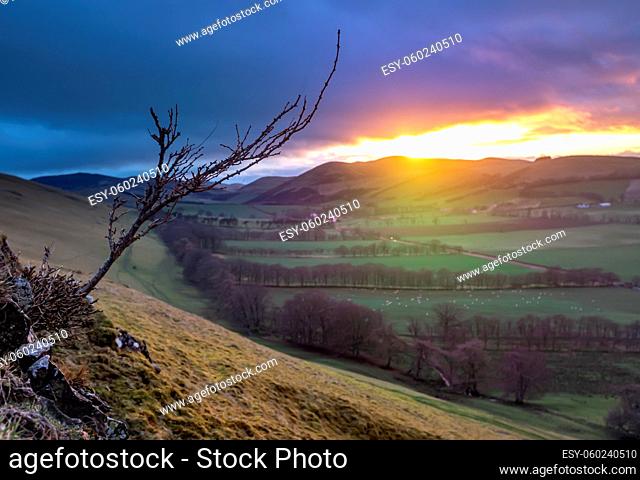 A Beam Of Light From A Winter Sunset Illuminating The Gentle Landscape Of An Agricultural Valley In The Scottish Borders, With Atmospheric Soft Focus