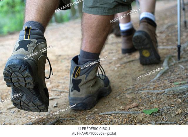 Hikers walking on path, close-up of feet