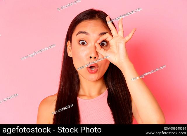 Beauty, fashion and lifestyle concept. Close-up of impressed beautiful asian girl see something amazing, stare at camera amazed